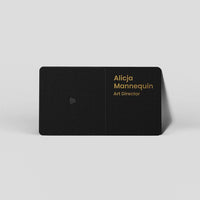 Black business card with gold text for Alicja Mannequin, Art Director, featuring minimalist design and contact icon.