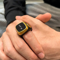 Smart ring with gold trim and digital display on finger, tracking health metrics